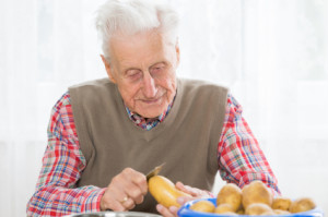 old man peeling potato